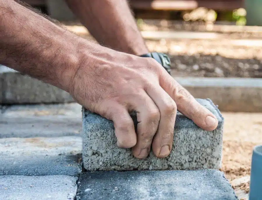 A person is building a brick path.