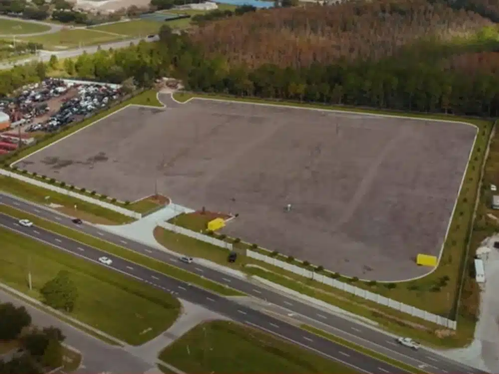 A large parking lot with cars parked on the side of it.