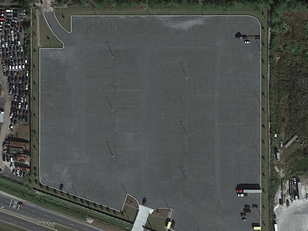 A large parking lot with many cars parked in it.