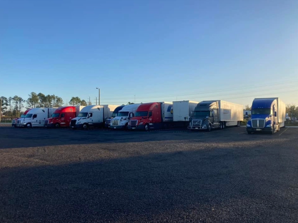 A row of semi trucks parked in a lot.