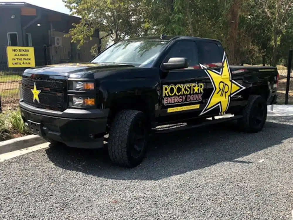 A black truck with rockstar energy drink written on it.