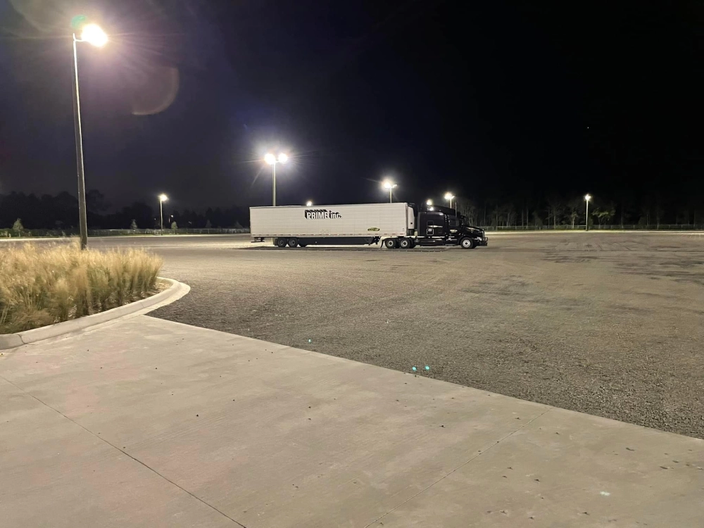 A semi truck parked in the middle of an empty parking lot.
